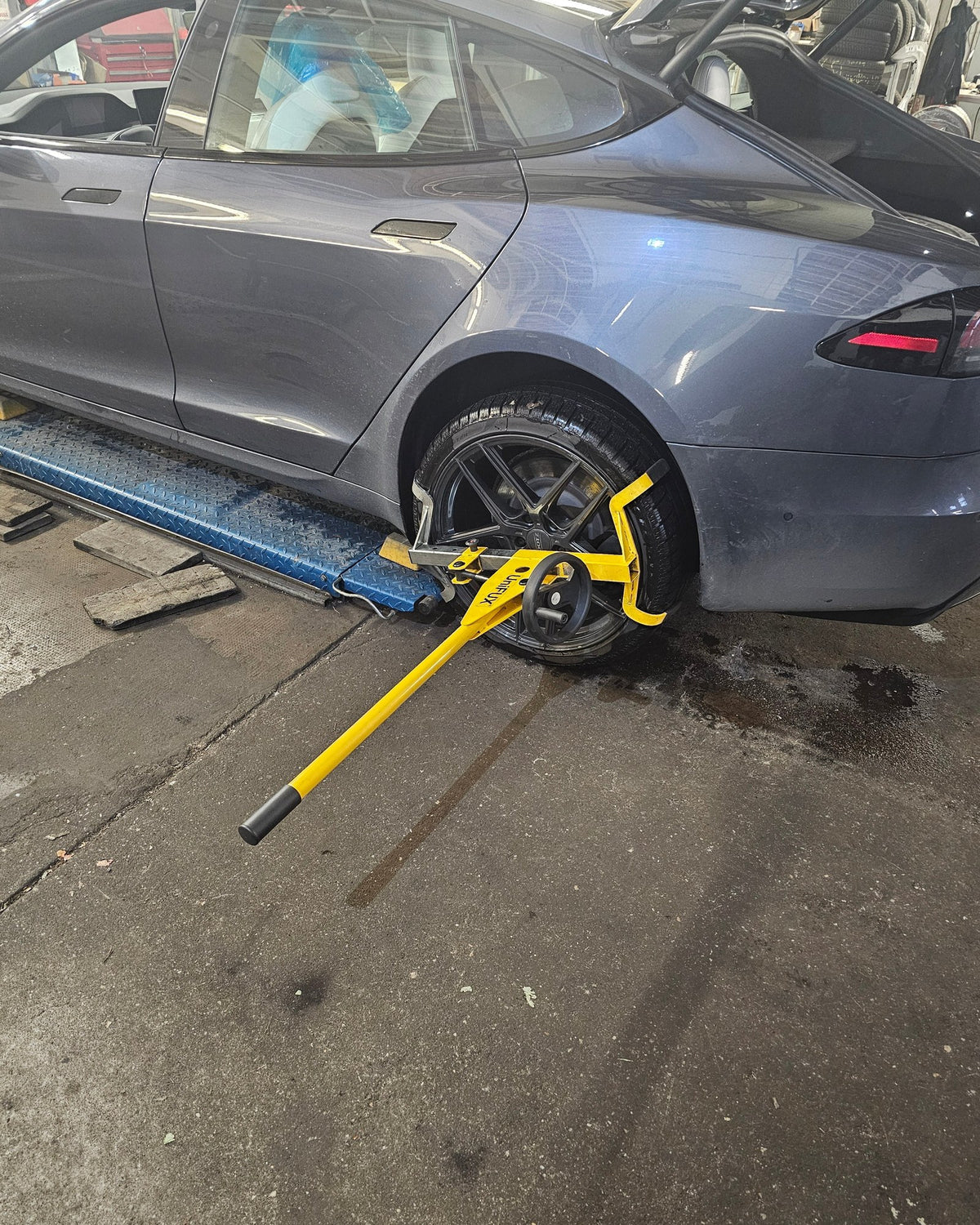 Achsspieltester am Rad eines Tesla Model S auf der Hebebühne